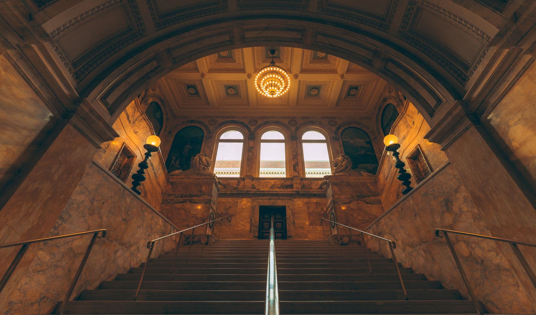 A grand marble staircase rising beneath a lit rotunda
