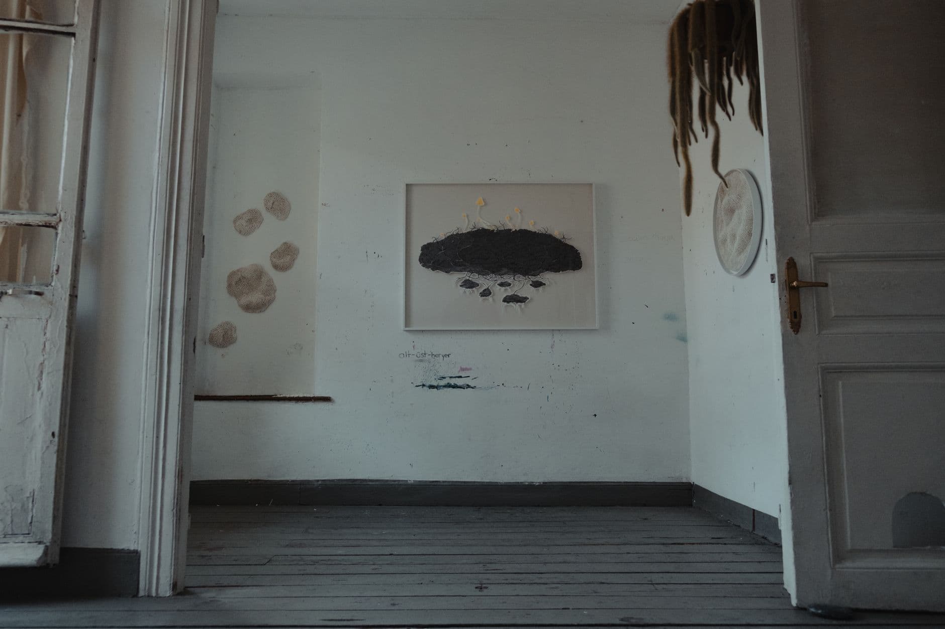A quiet, near-empty gallery room with a single hung work