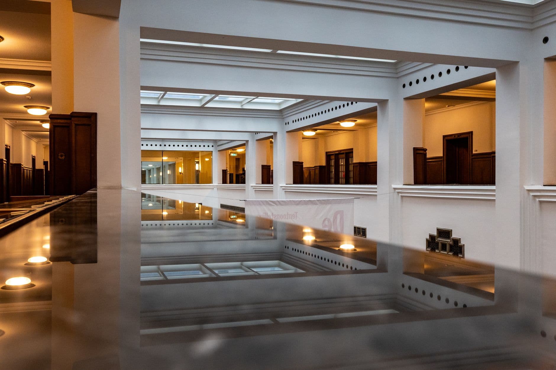 A bright, empty gallery receding under skylights